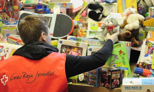 Un voluntari de la Creu Roja guardant joguines recollides