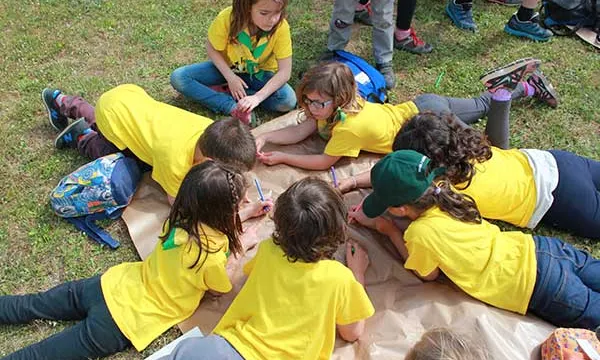 Un grup d'infants fent una activitat damunt la gespa