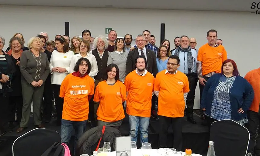 Les persones amb samarreta taronja són les primeres voluntàries del projecte #JoTbPuc. Van fer de voluntaris/àries al Sopar de Nadal de l'entitat.