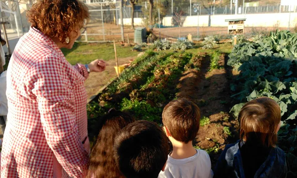 Mestra i alumnes a l'hort de l'Escola Mediterrània