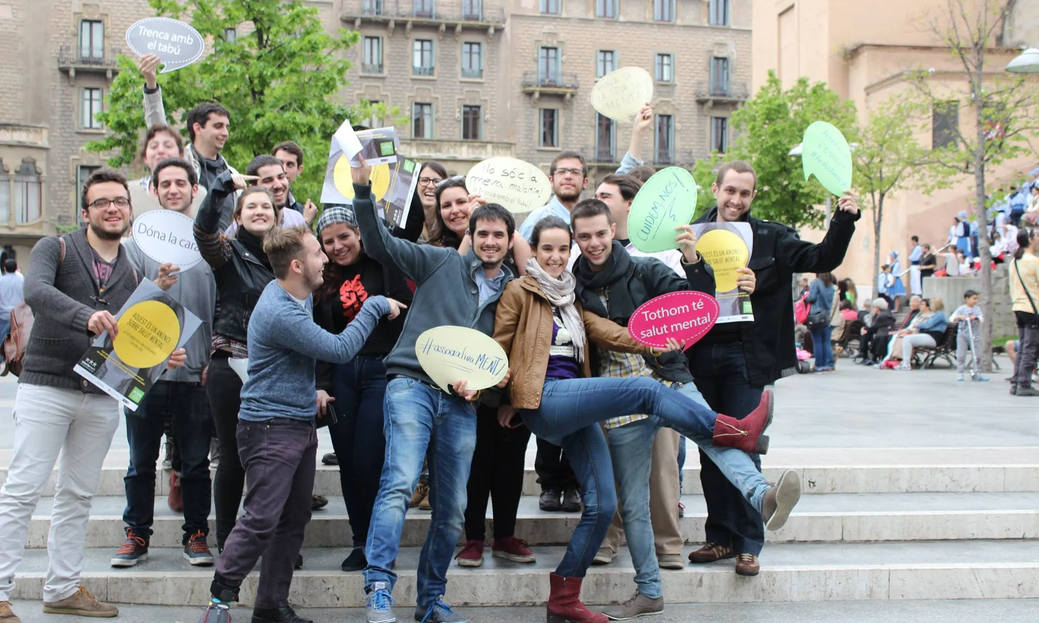 Participants de la 10a Àgora Jove amb cartells tipus bafarada que contenen consignes de participació.