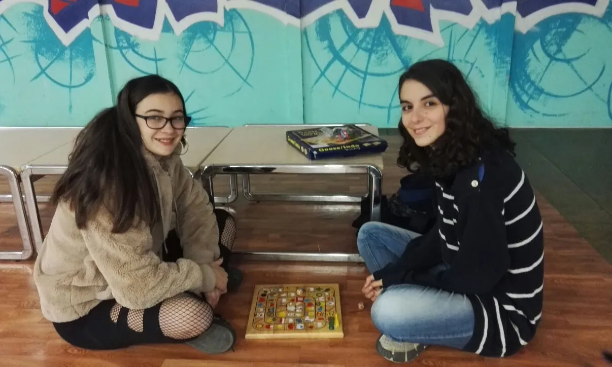 Un dels 'tàndems' format per una noia universitària i una jove, jugant a un joc de taula.