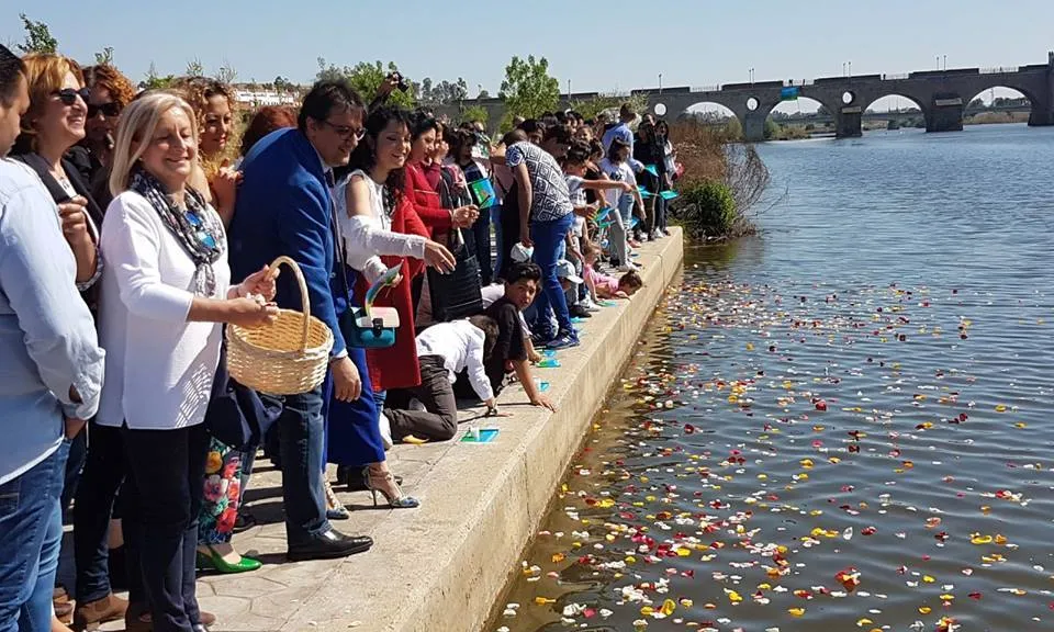 Persones llançant pètals al riu per celebrar el 8 d'abril, Dia Internacional del Poble Gitano