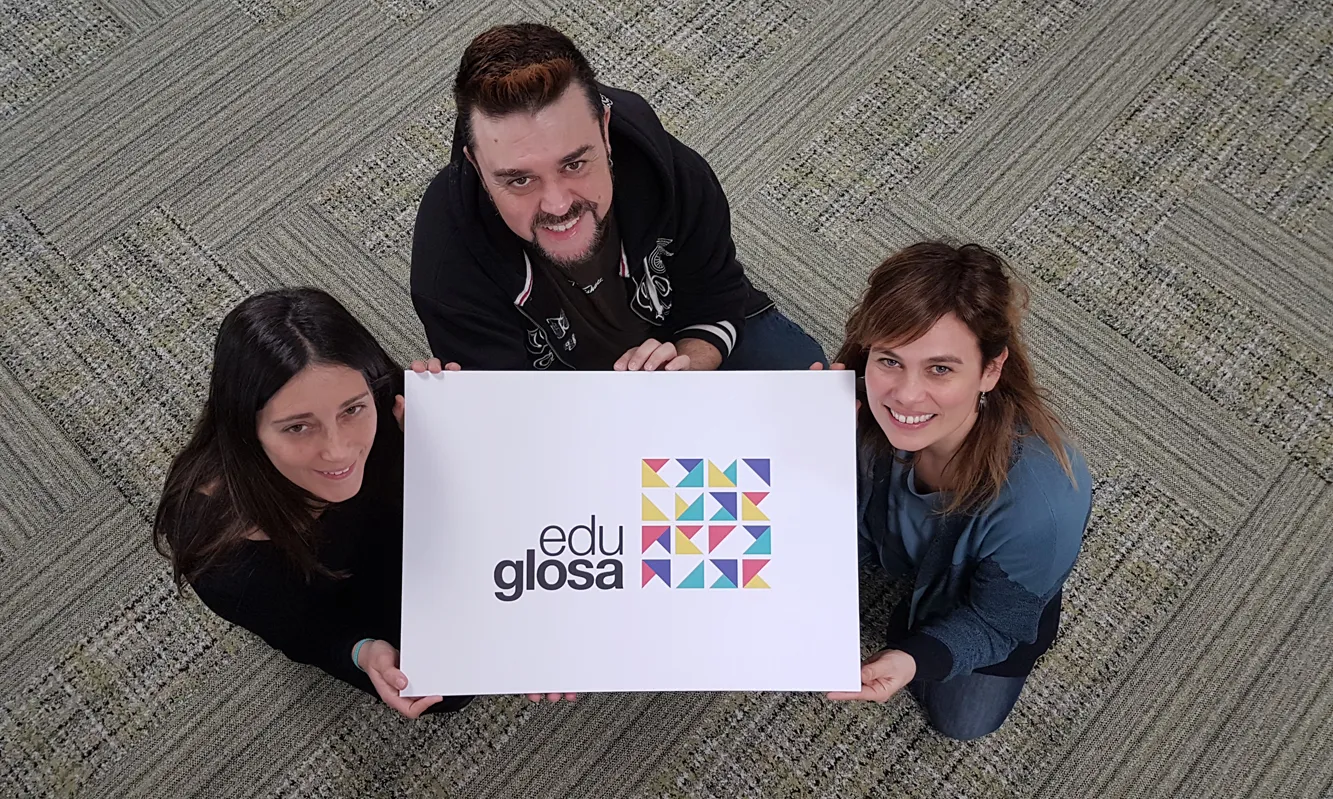 Tres membres d'Eduglosa mostren el logotip del projecte