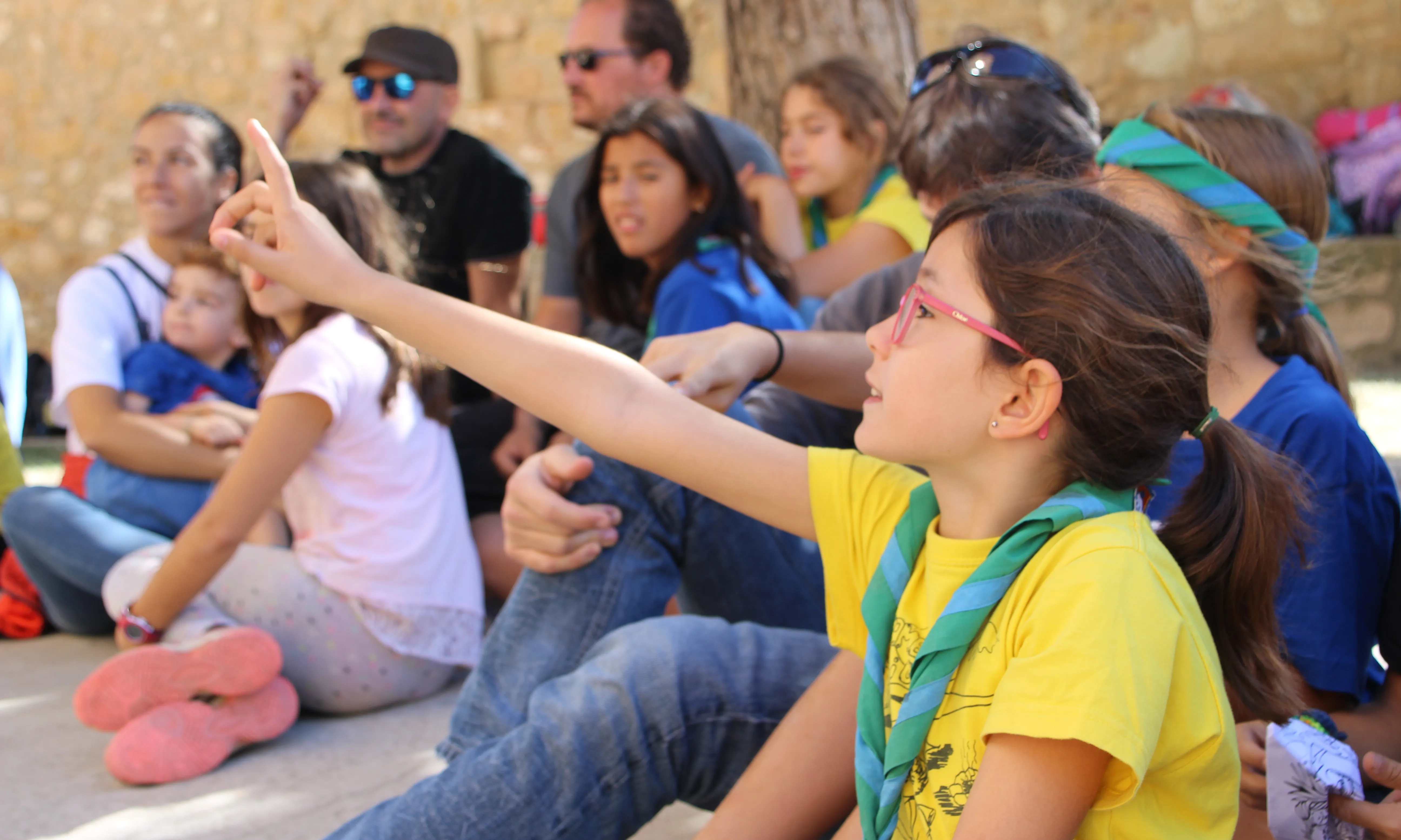 Una nena participants en una activitat amb la mà alcaça per dir la seva.