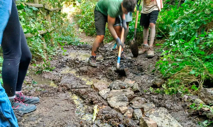 Dos joves treballen en un petit riu