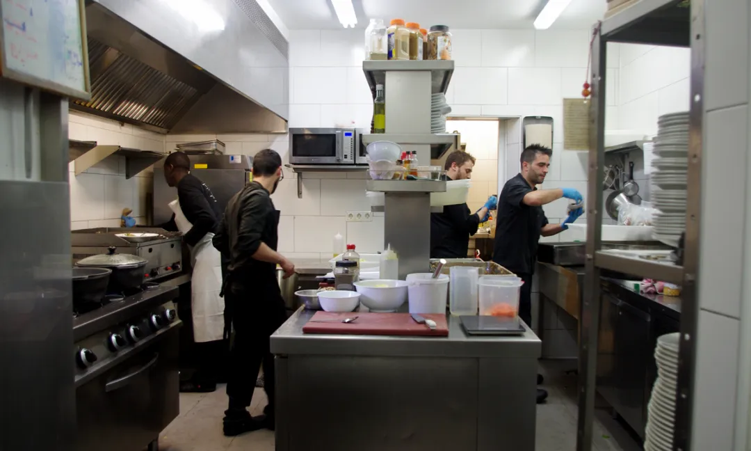 Diverses persones treballant en la cuina d'un restaurant cooperatiu