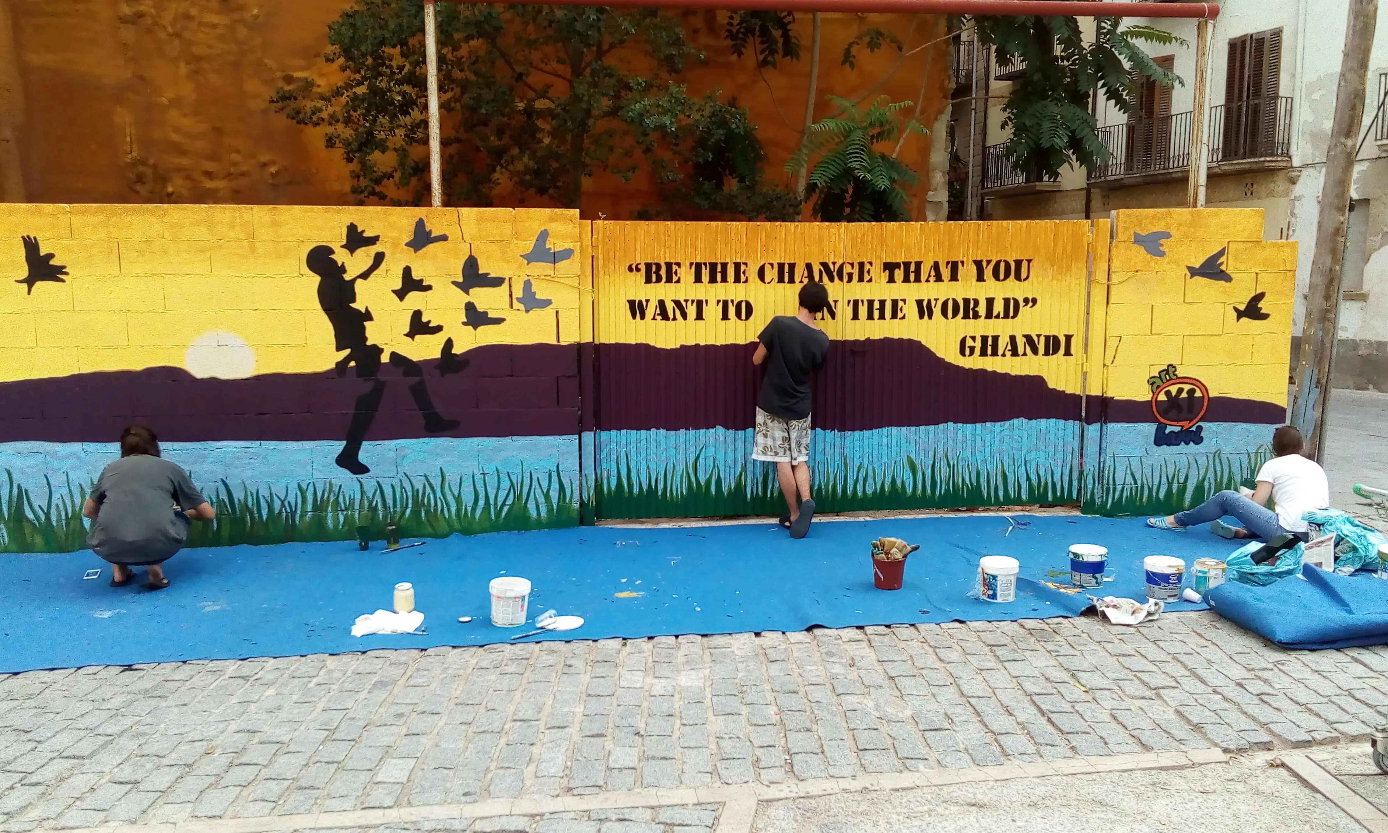Paret pintada en blau i groc amb un lema solidari