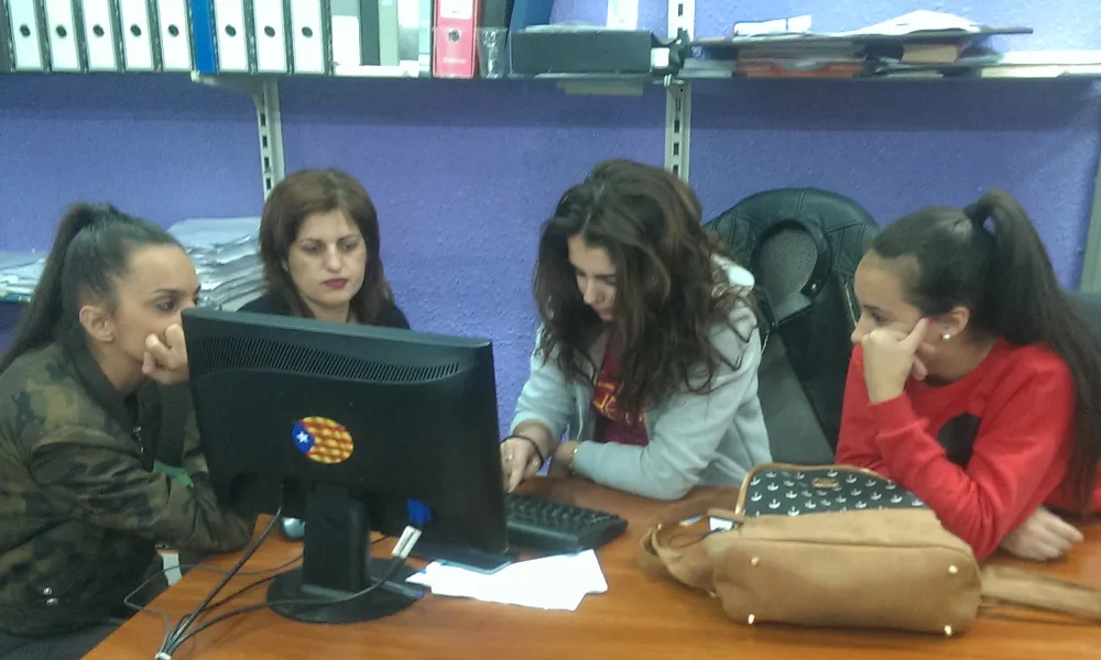 Grup de joves al voltant d'un ordinador