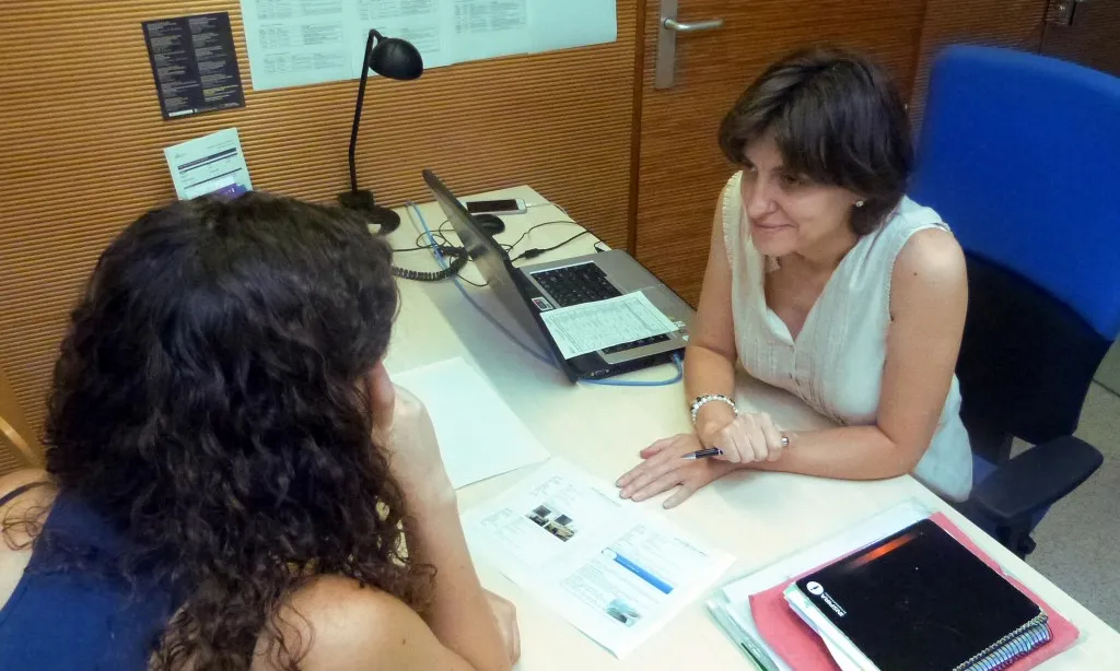 Una treballadora de l'Oficina de l'Habitatge assessorant una jove.