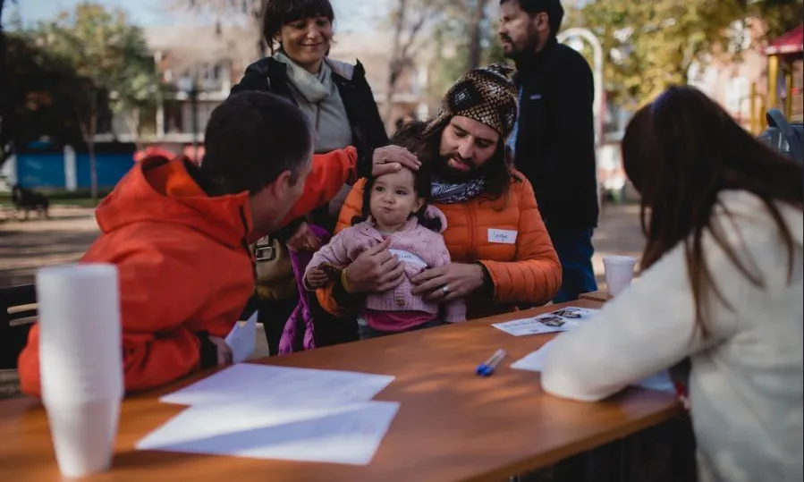 Taula amb diverses persones en una plaça en ple procés participatiu