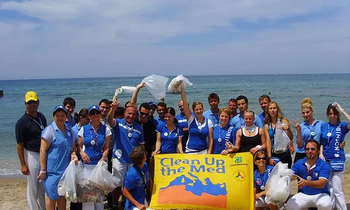 Un grup d'adults en una platja participant en la campanya 'Clean up the Med'