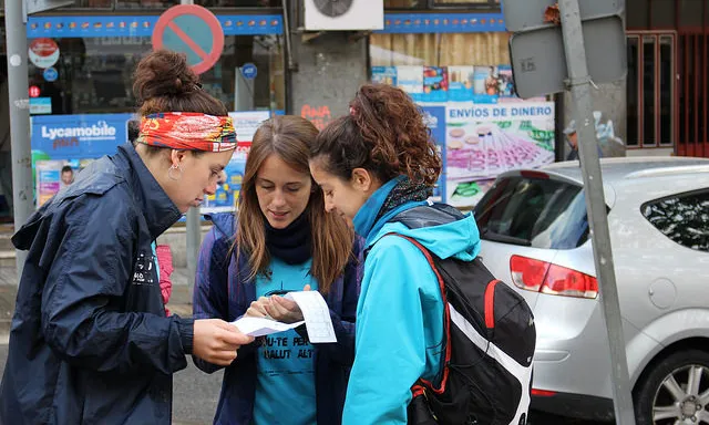Participants a la Cursa d'Orientació Solidària mirant el mapa.