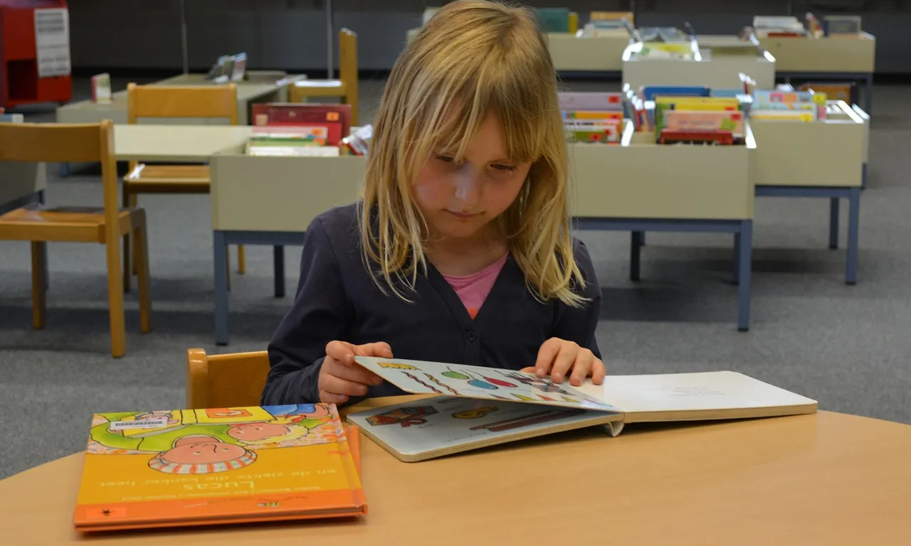 Una nena llegint en una biblioteca