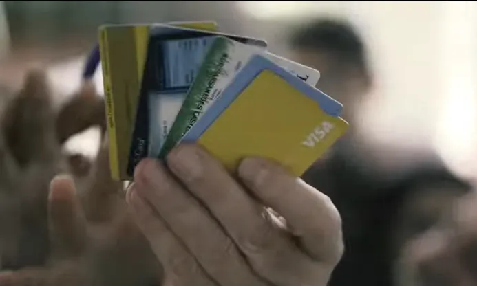 Fotograma del vídeo de la campanya que mostra unes targetes bancàries en una mà