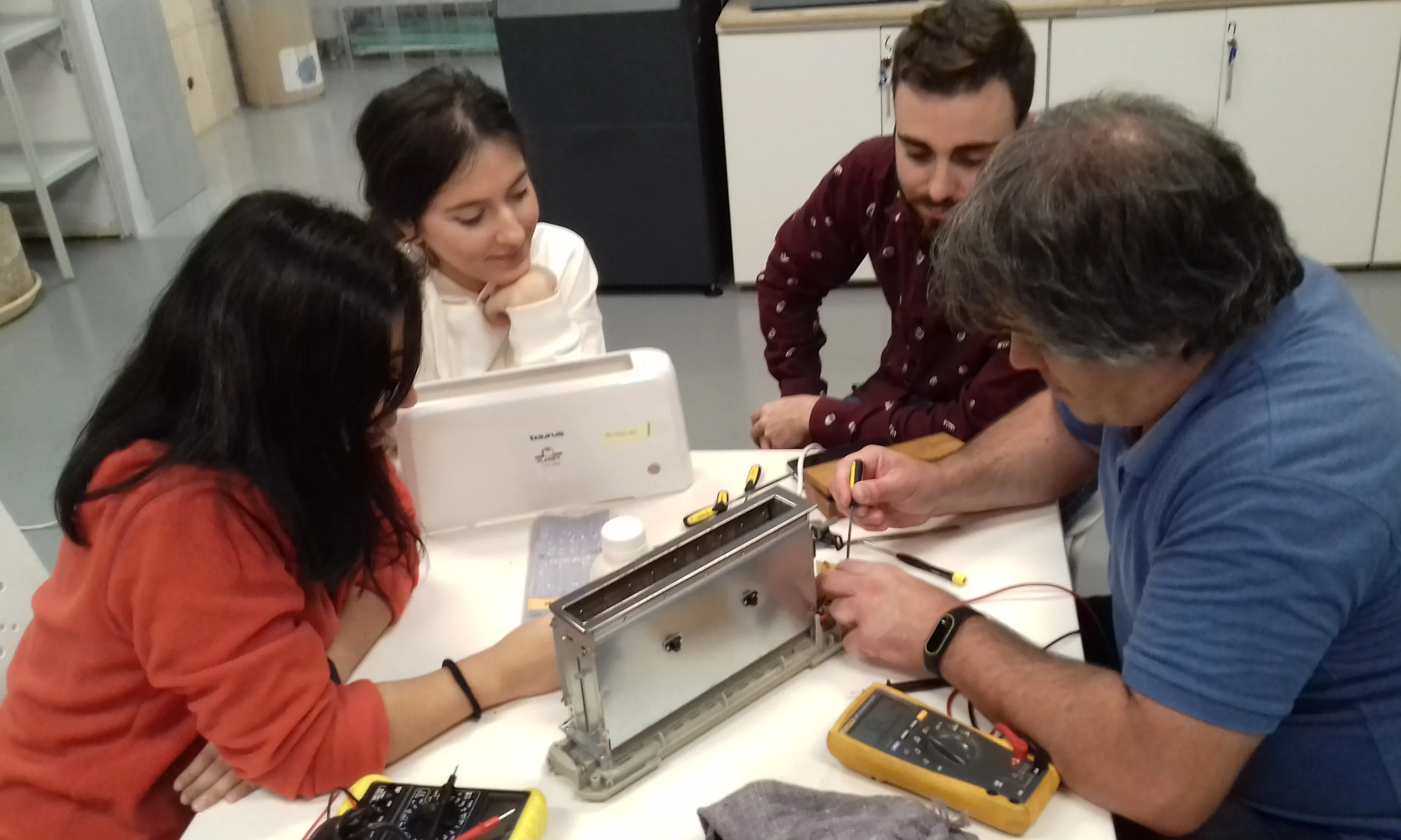 Tres joves aprenent a reparar una torradora