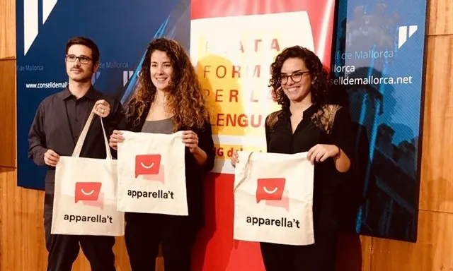 Tres participants en la iniciativa mostren bosses de roba amb el seu logotip