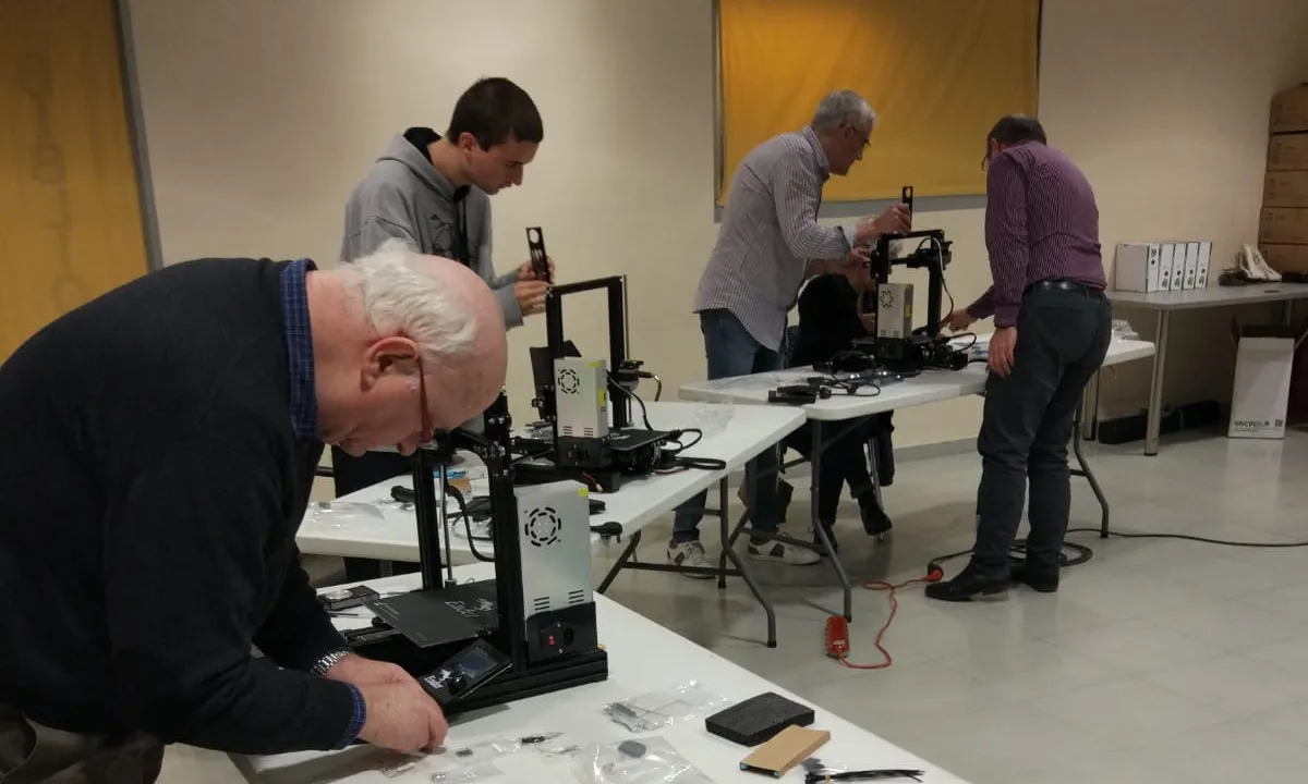Persones de diferents edats treballant amb impressores 3D