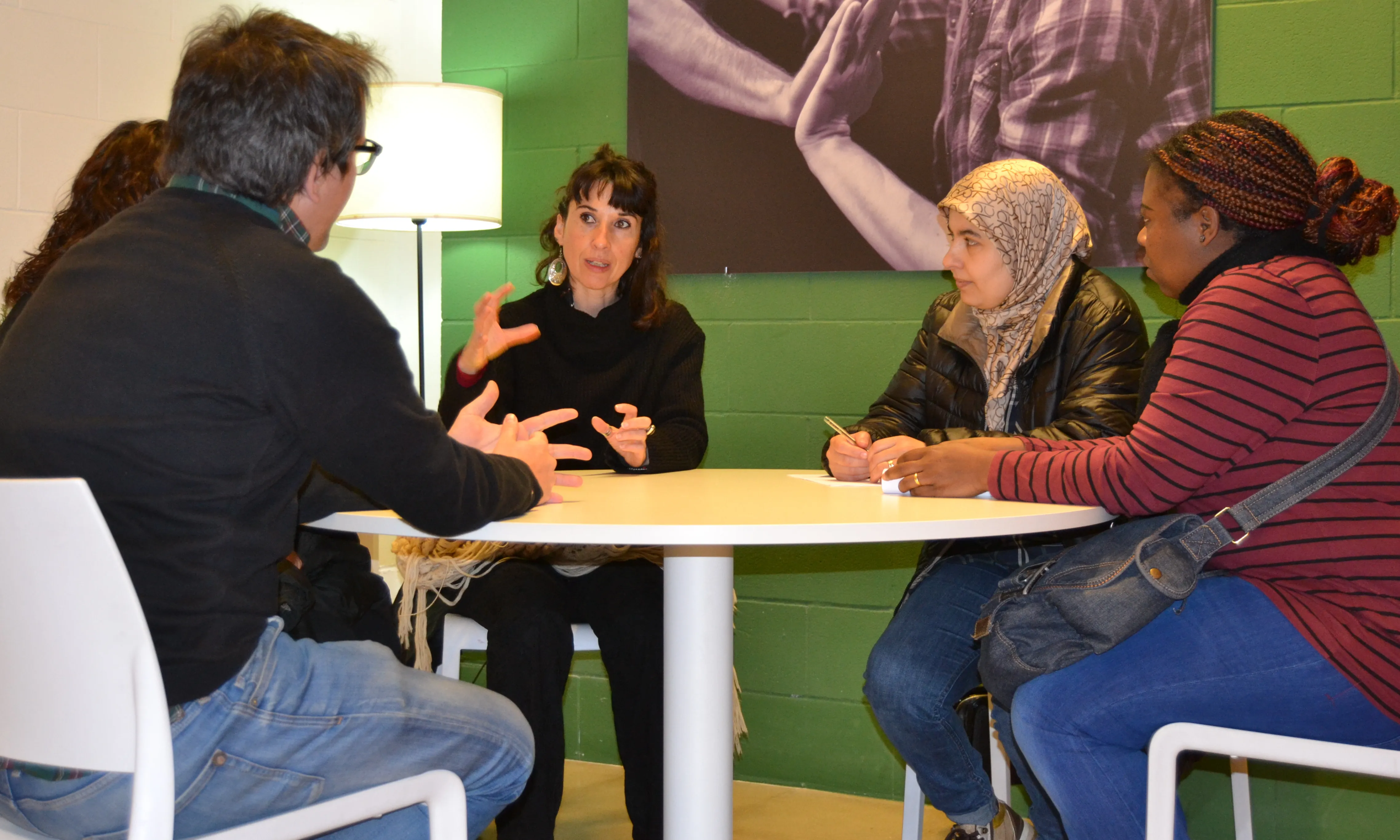 La Neus reunida amb un equip del projecte 'A-porta'