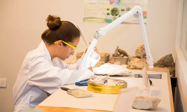 Noia en una laboratori mirant a través del microscopi