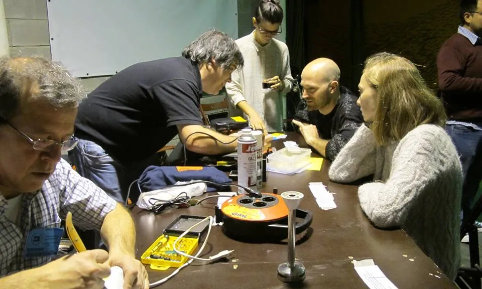Persones reparadores ajuden a d'altres que porten els seus aparells elèctrics i electrònics per arreglar