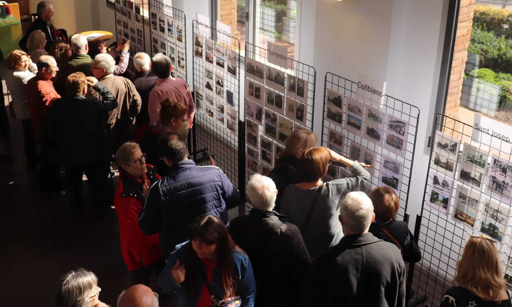 Gent mirant l'exposició de postals de la BlogL'Hosfera