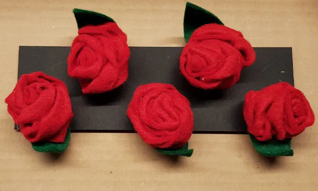 Roses de feltre amb agulla i pinça fetes a l'espai La Troballa de la Fundació Arrels.