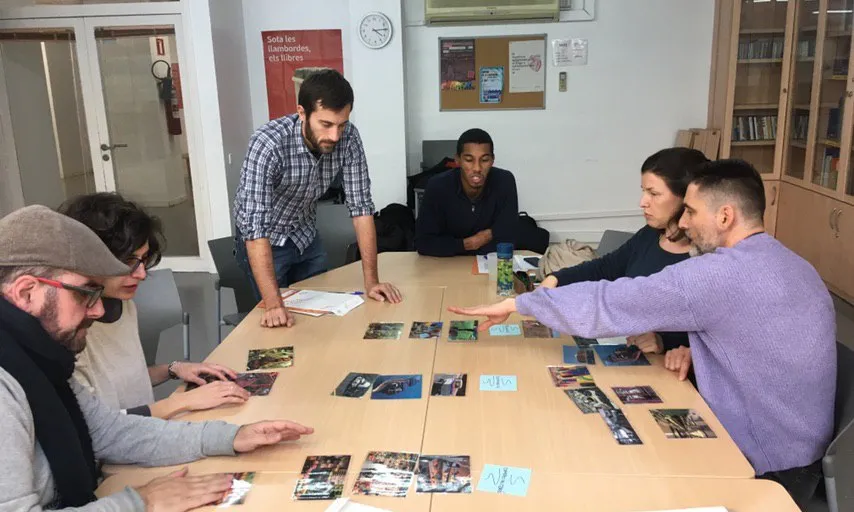 Sis persones realitzen una activitat amb fotografies