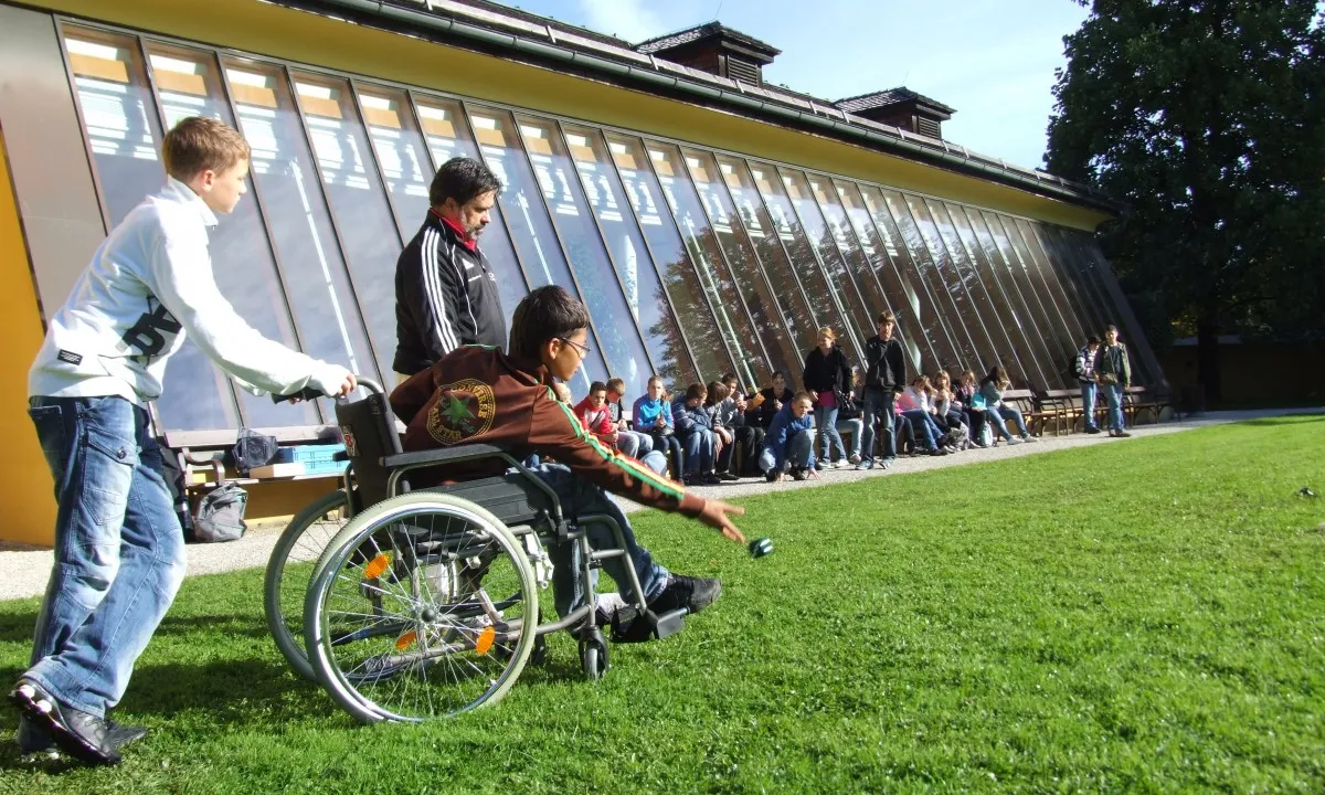 Un nen amb mobilitat reduïda participa a una activitat esportiva.