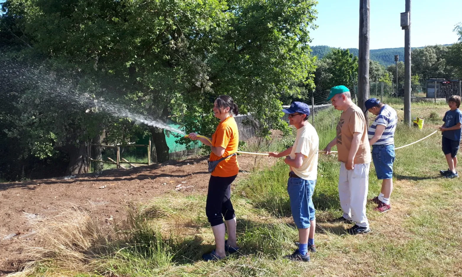 Usuaris i usuàries de Sant Tomàs regant amb una mànega