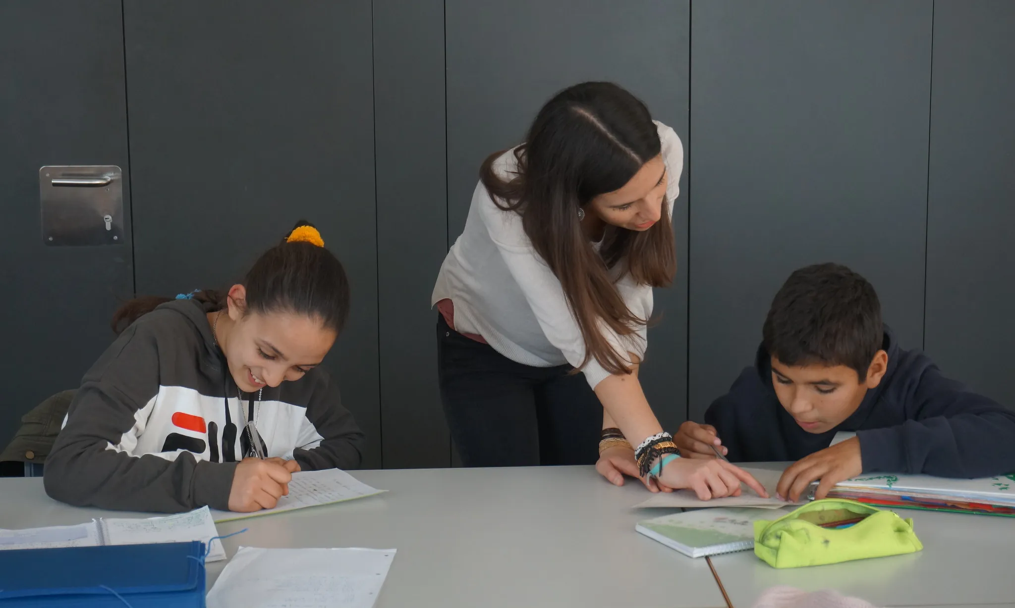 Noia fent reforç educatiu a dos infants