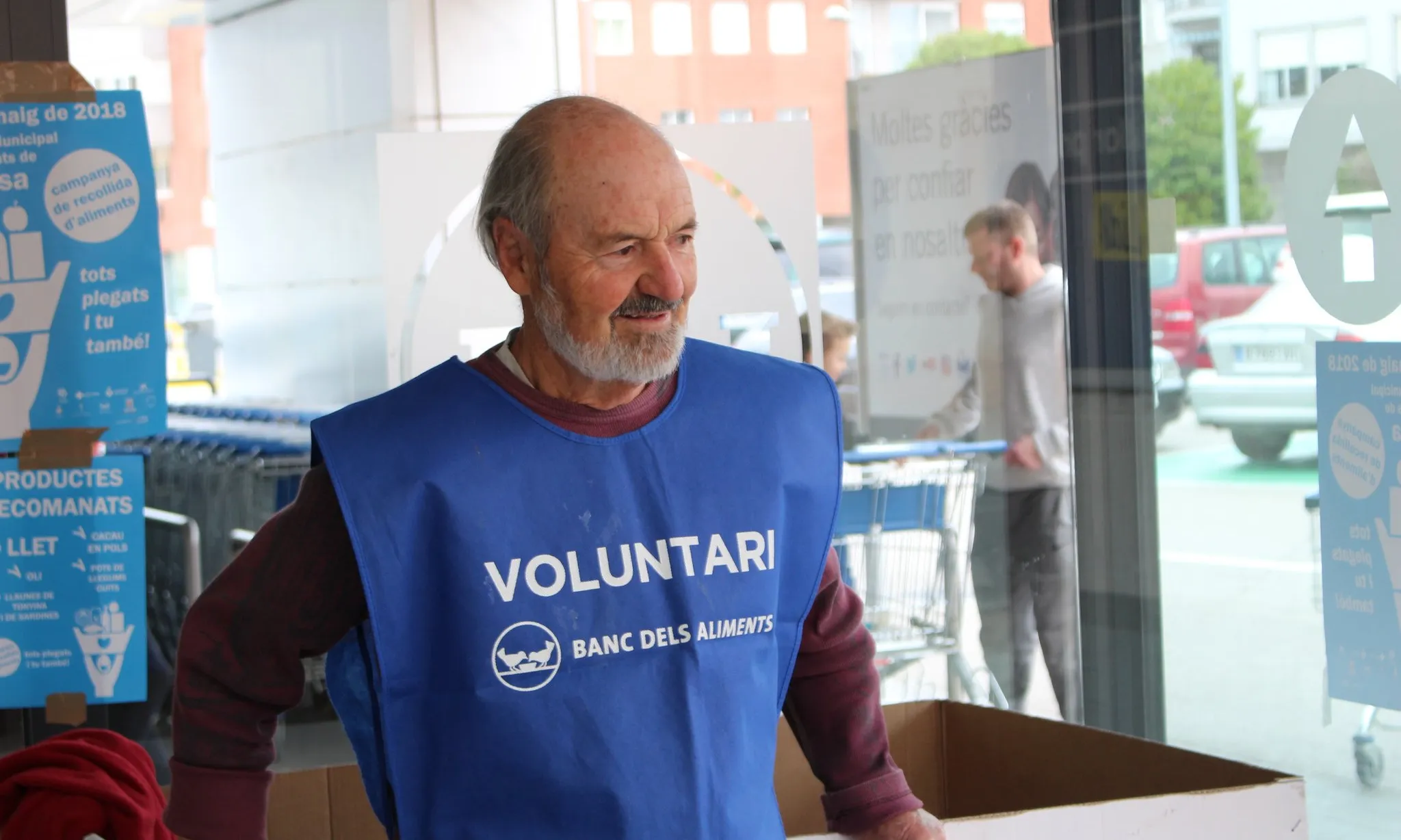 Un voluntari col·labora en la recollida d'aliments.