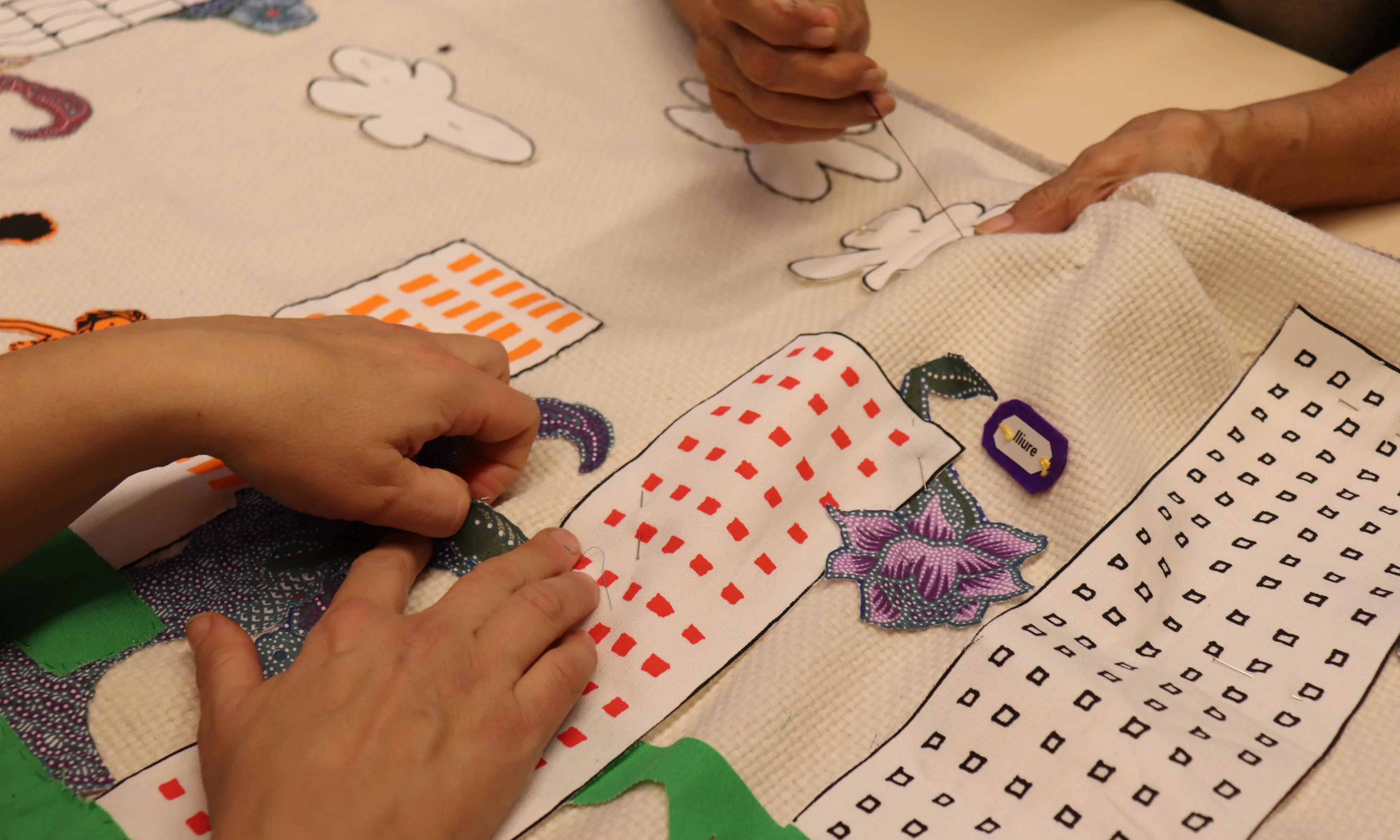 Dones cosint mural tèxtil