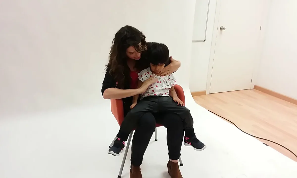 Alba Florejachs durant la sessió fotogràfica juga amb l'Olenka, un dels infants amb pluridiscapacitat.