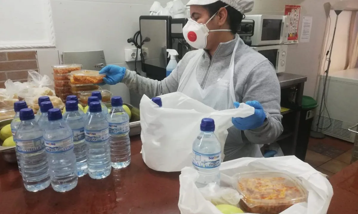 Una treballadora de Formació i Treball prepara els kits d'alimentació per a persones en risc d'exclusió.