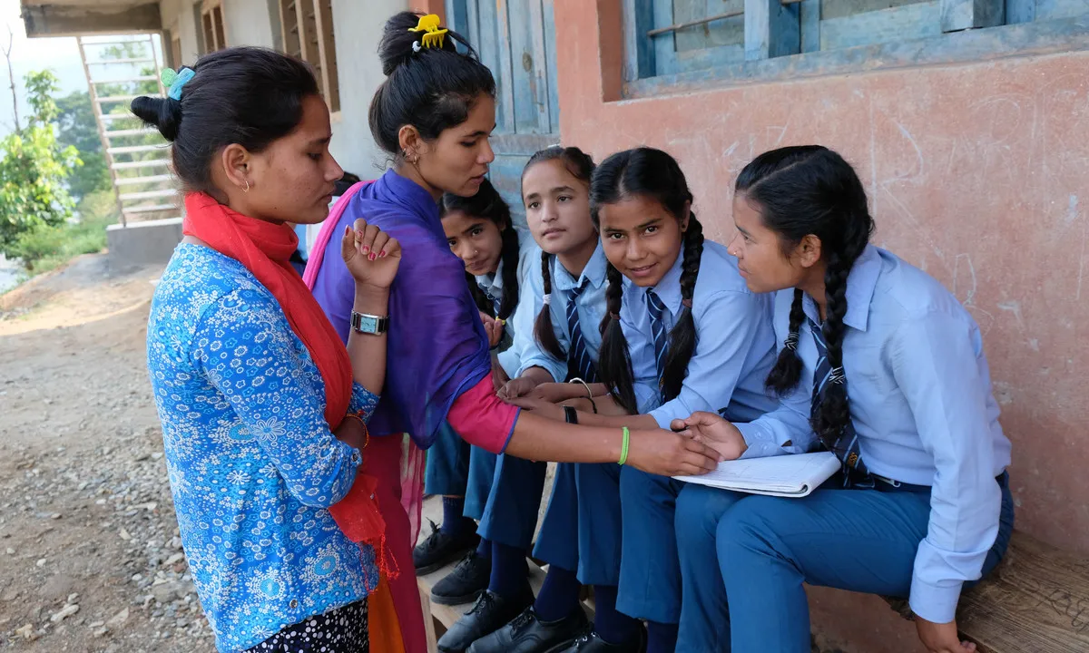 Tejana, a Oligaun amb noies a favor de l'ús de a copa menstrual, i noies reticents