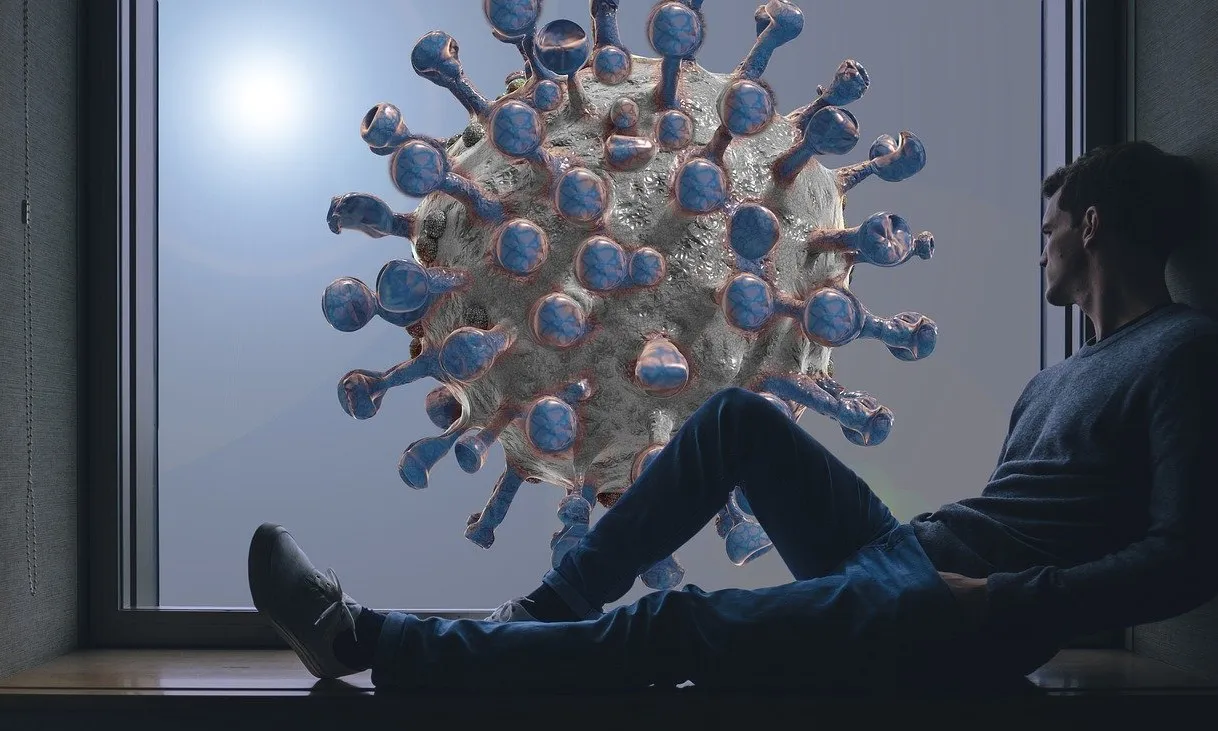 Noi mirant per la finestra on es veu la imatge ampliada del coronavirus