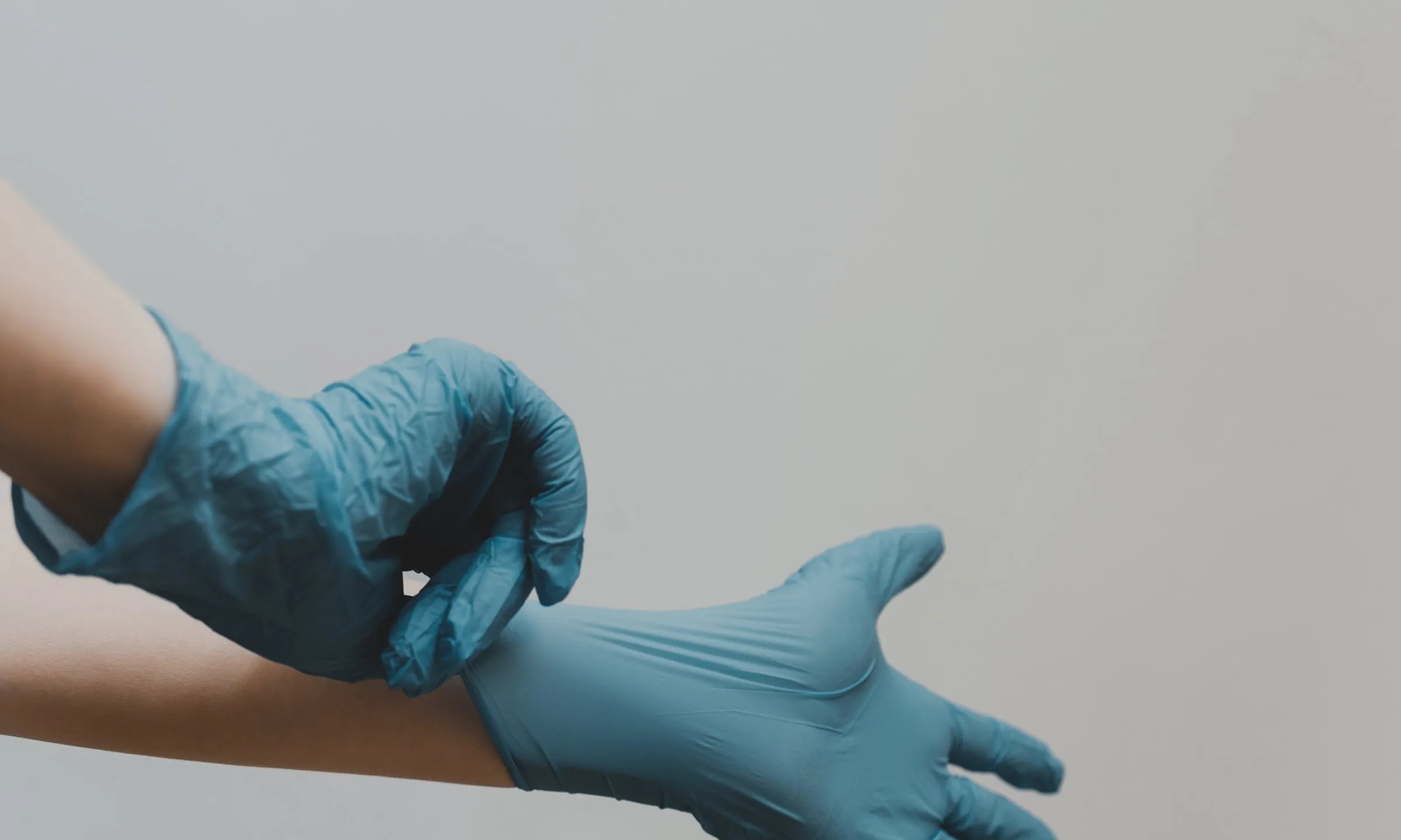 Dues mans posant-se guants sanitaris