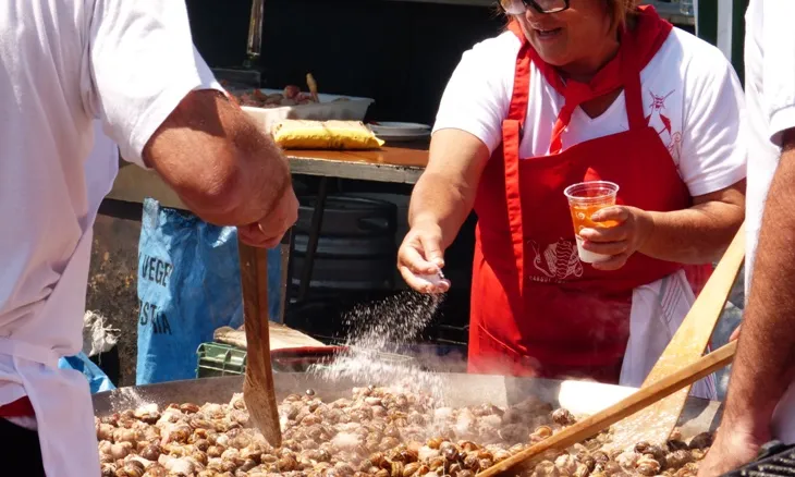 Home i dona cuinant en un paella gegant