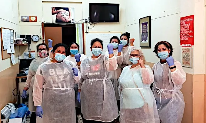 Dones de l'associació Mujeres Migrantes Diversas repartint cistelles de productes bàsics i material de protecció. 