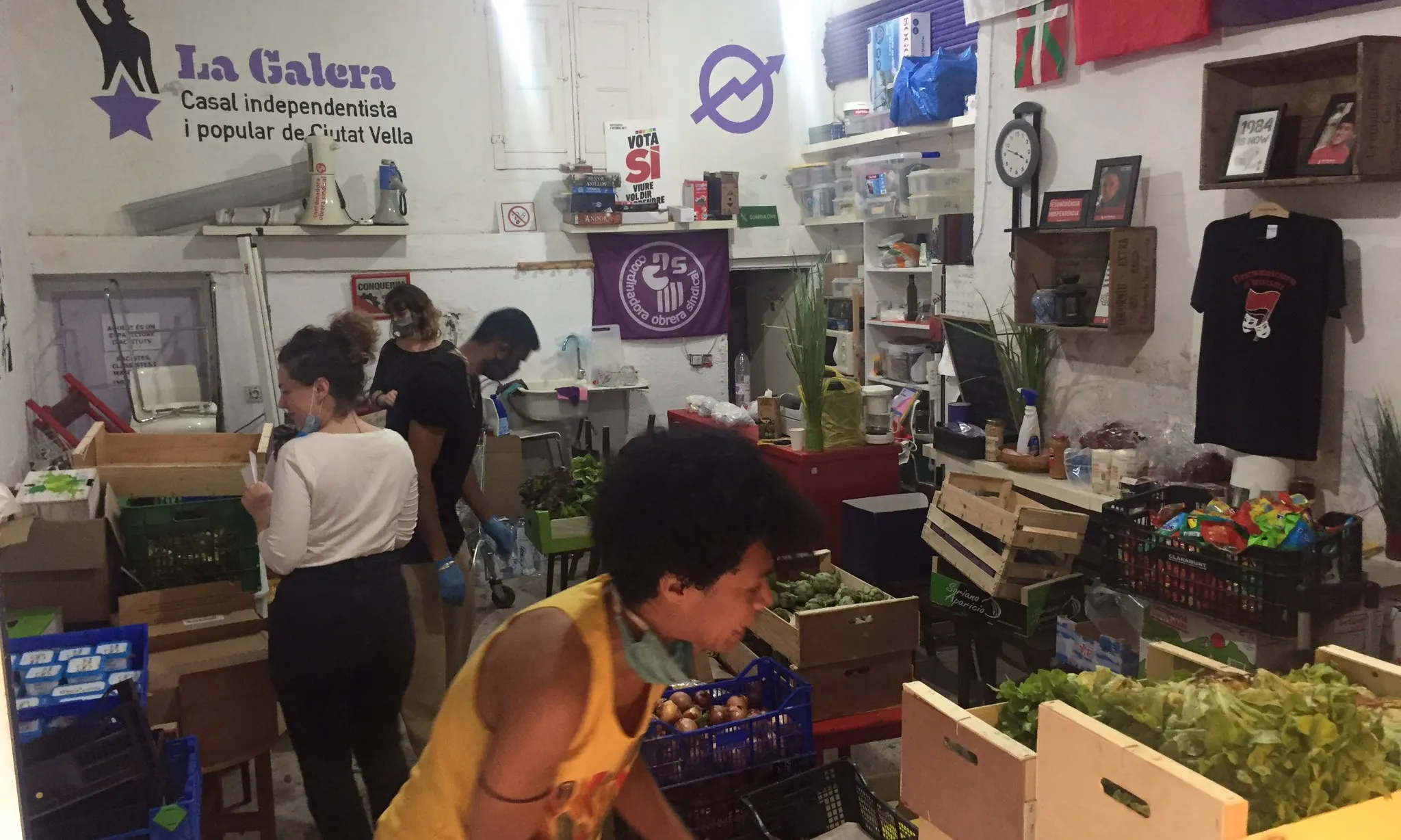 Persones implicades en la Xarxa Popular d'Aliments del Raval organitzant els aliments per donar, en La Galera 