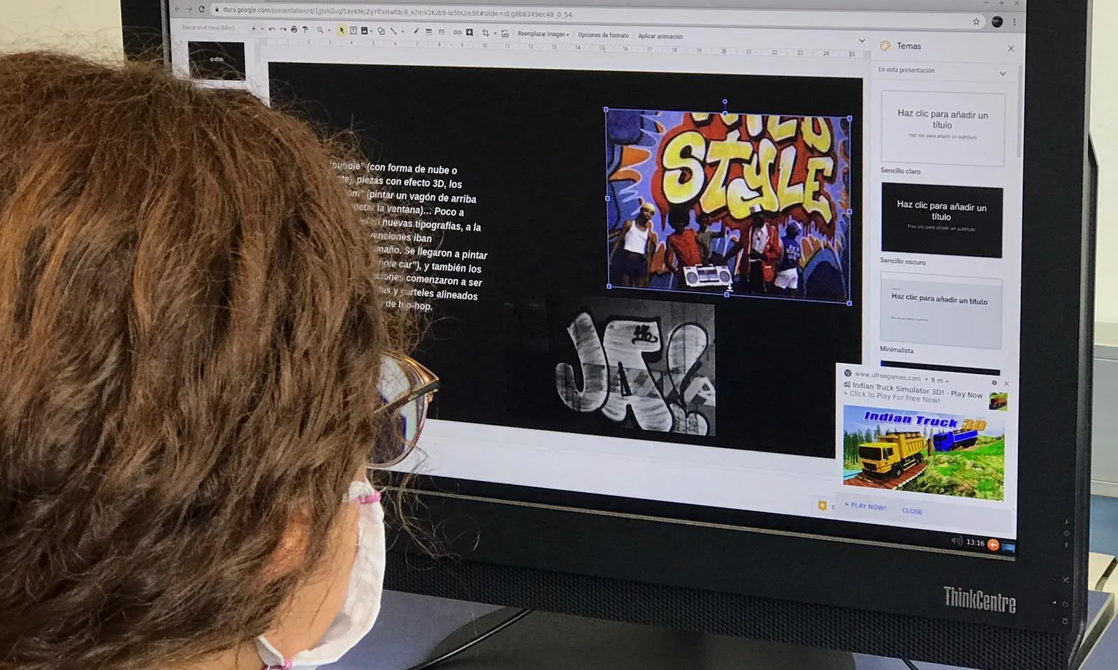 Noia amb mascartea mirant la pantalla de l'ordinador