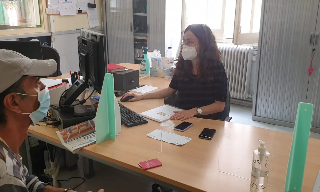 Noia amb mascareta atenent a darrere d'una taula
