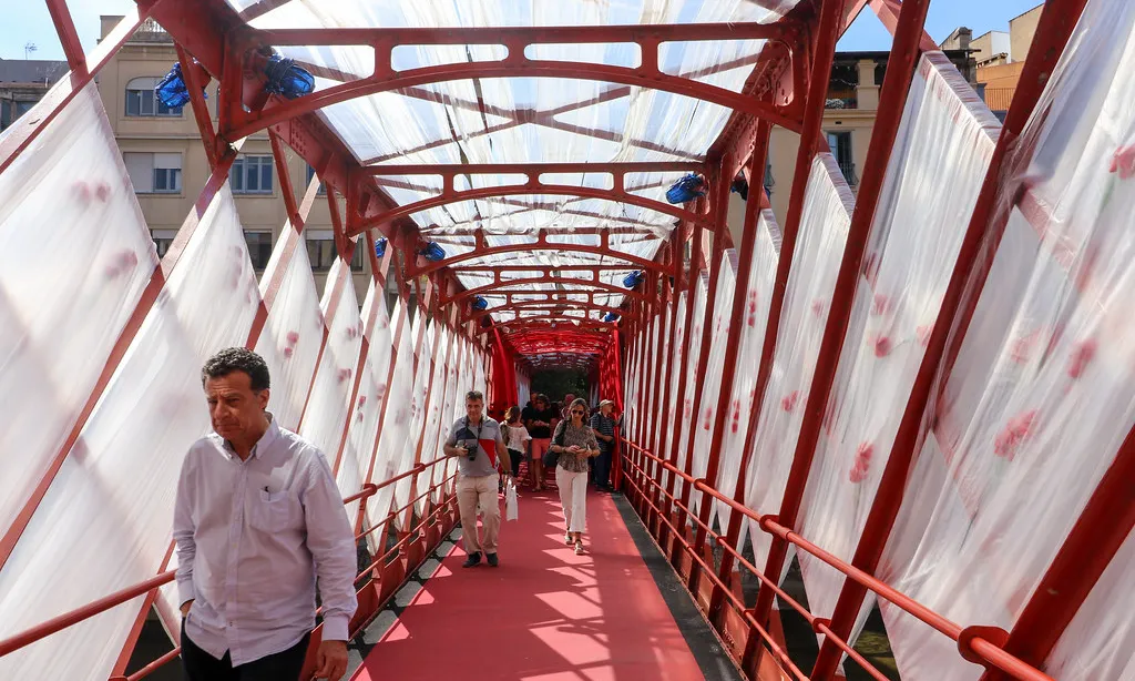 Ciutadania de Girona caminant pel pont de ferro.