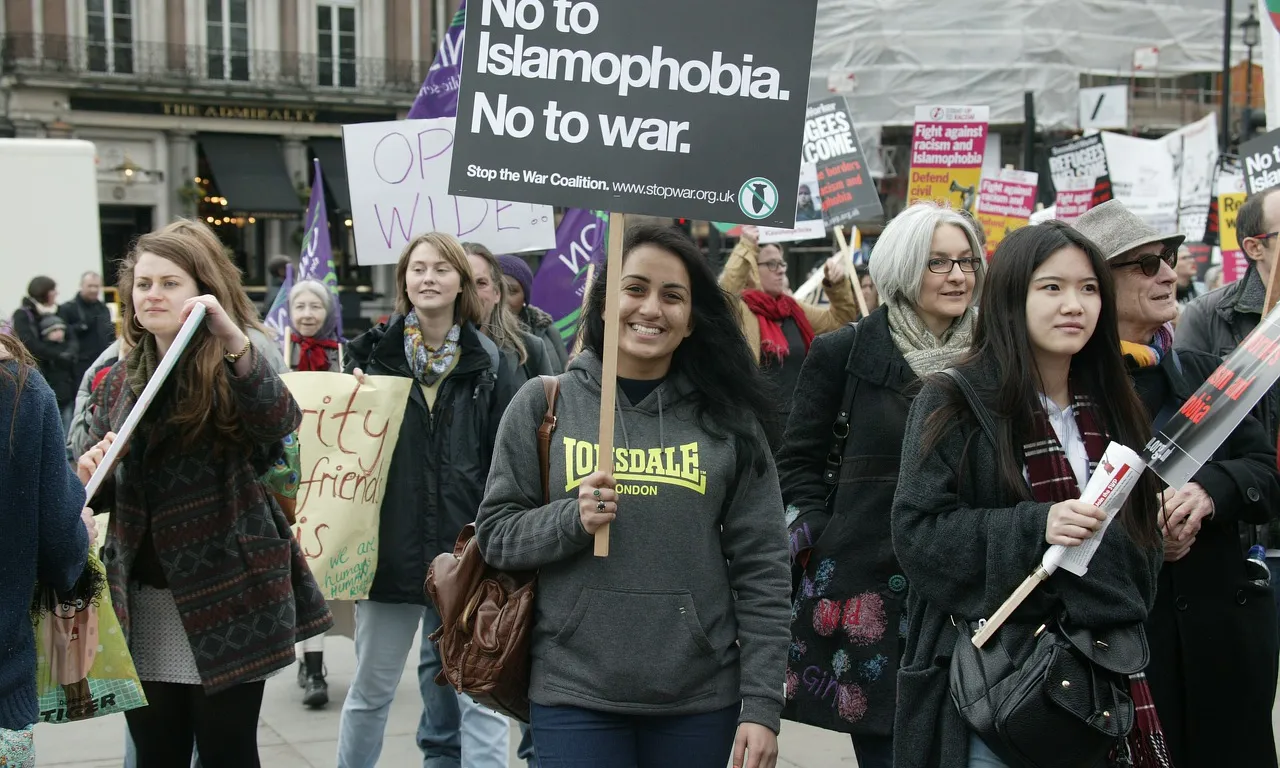 Gent participant en una manifestació, amb una pancarta contra la islamofòbia i la guerra (en anglès)