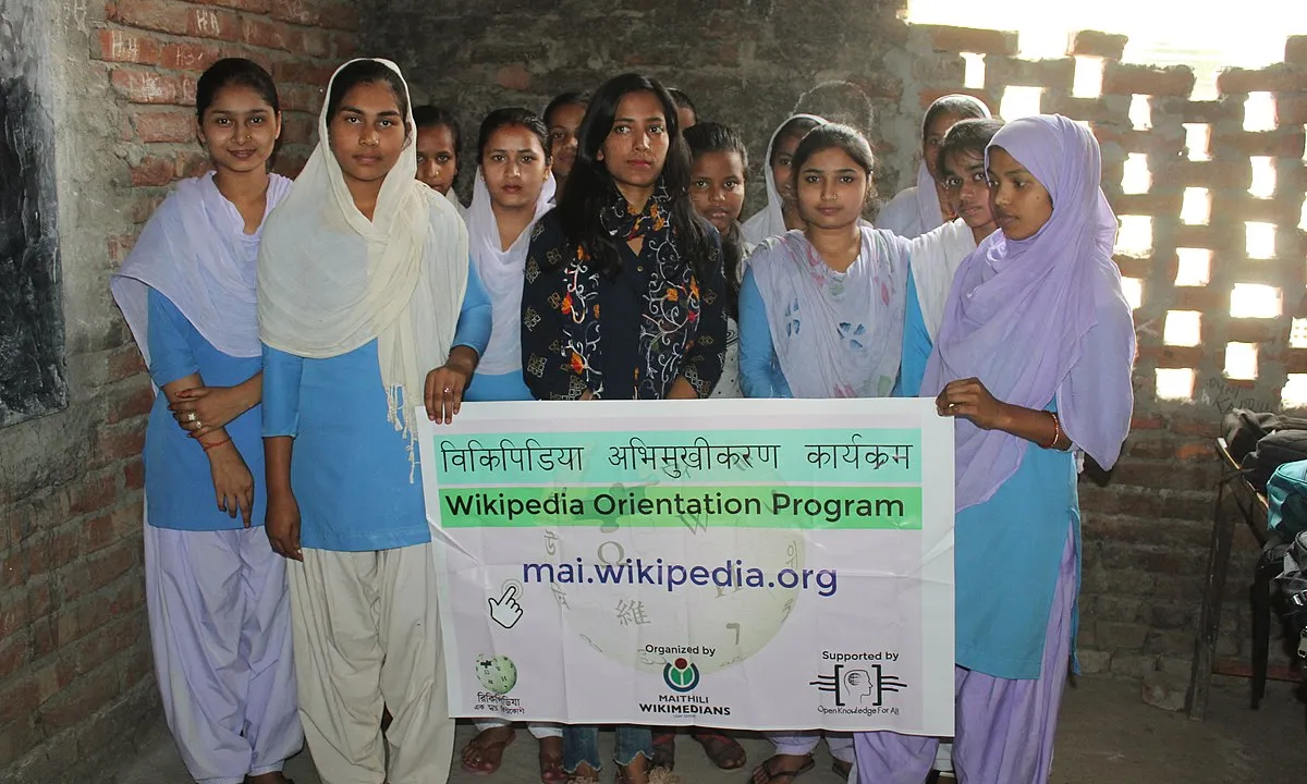 Fotografia d'un grup de noies amb un cartell de la Wikipedia. Imatge de Nilamkarn. Llicència d'ús CC BY-SA 4.0