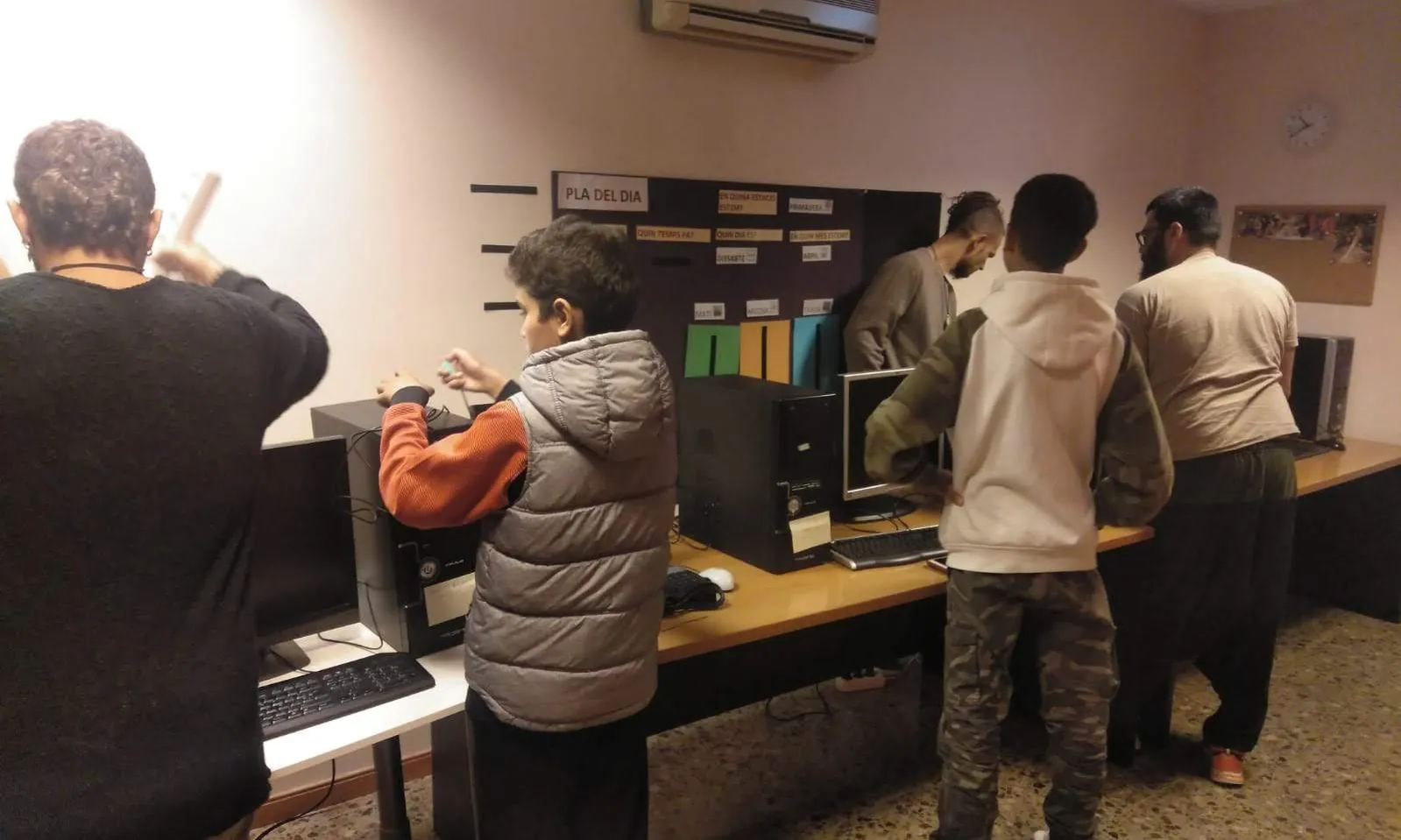 Fotografia d'uns joves del barri de Montserrat fent un donatiu d'ordinadors. Imatge de l'AAVV Montserrat.