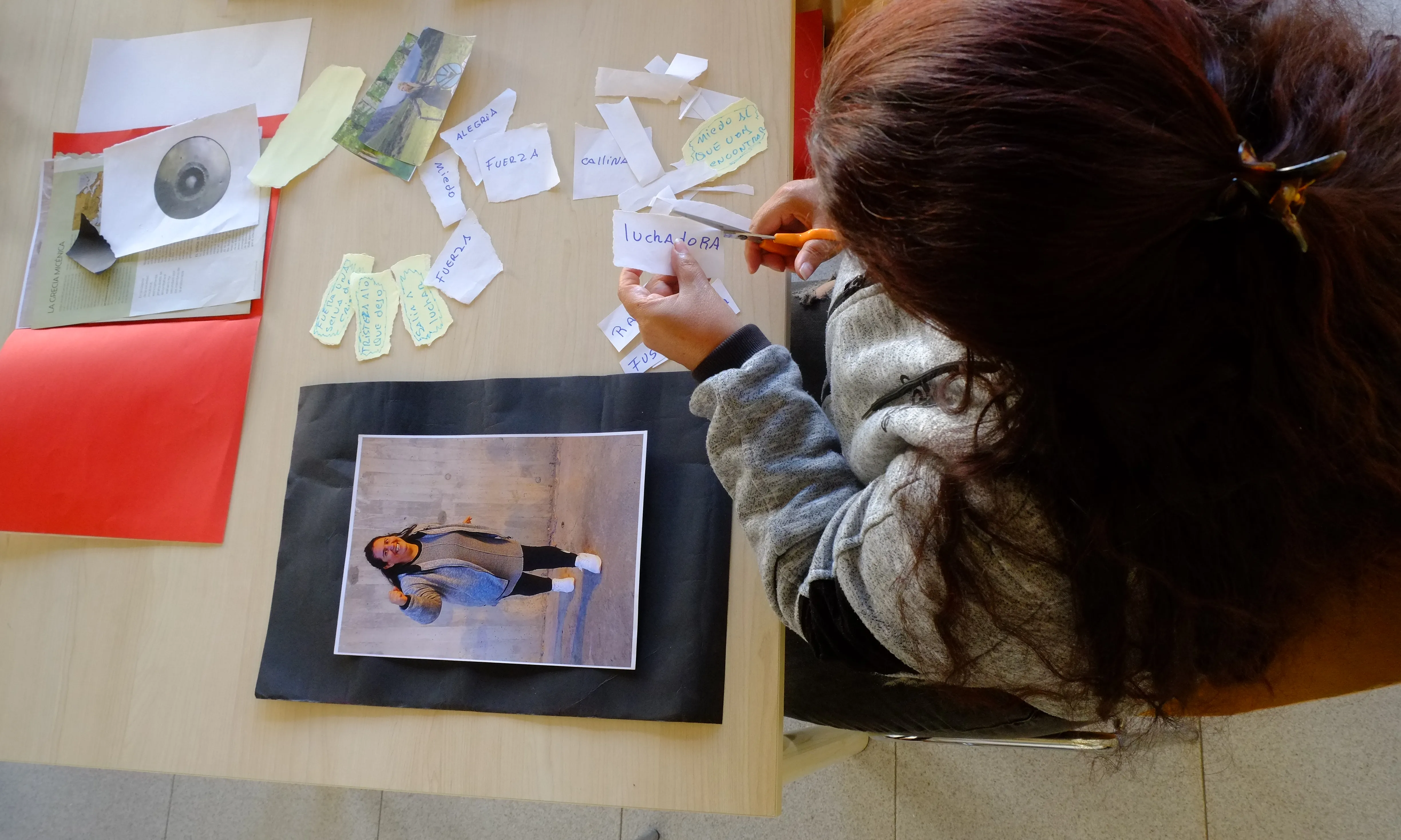 Una de les dones que participa del taller fa un collage