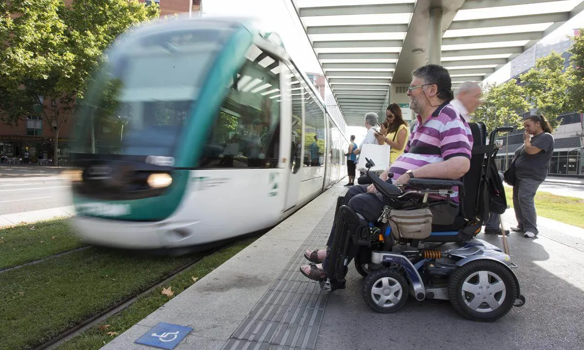 Una persona amb cadira de rodes esperant el tramvia per desplaçar-se.