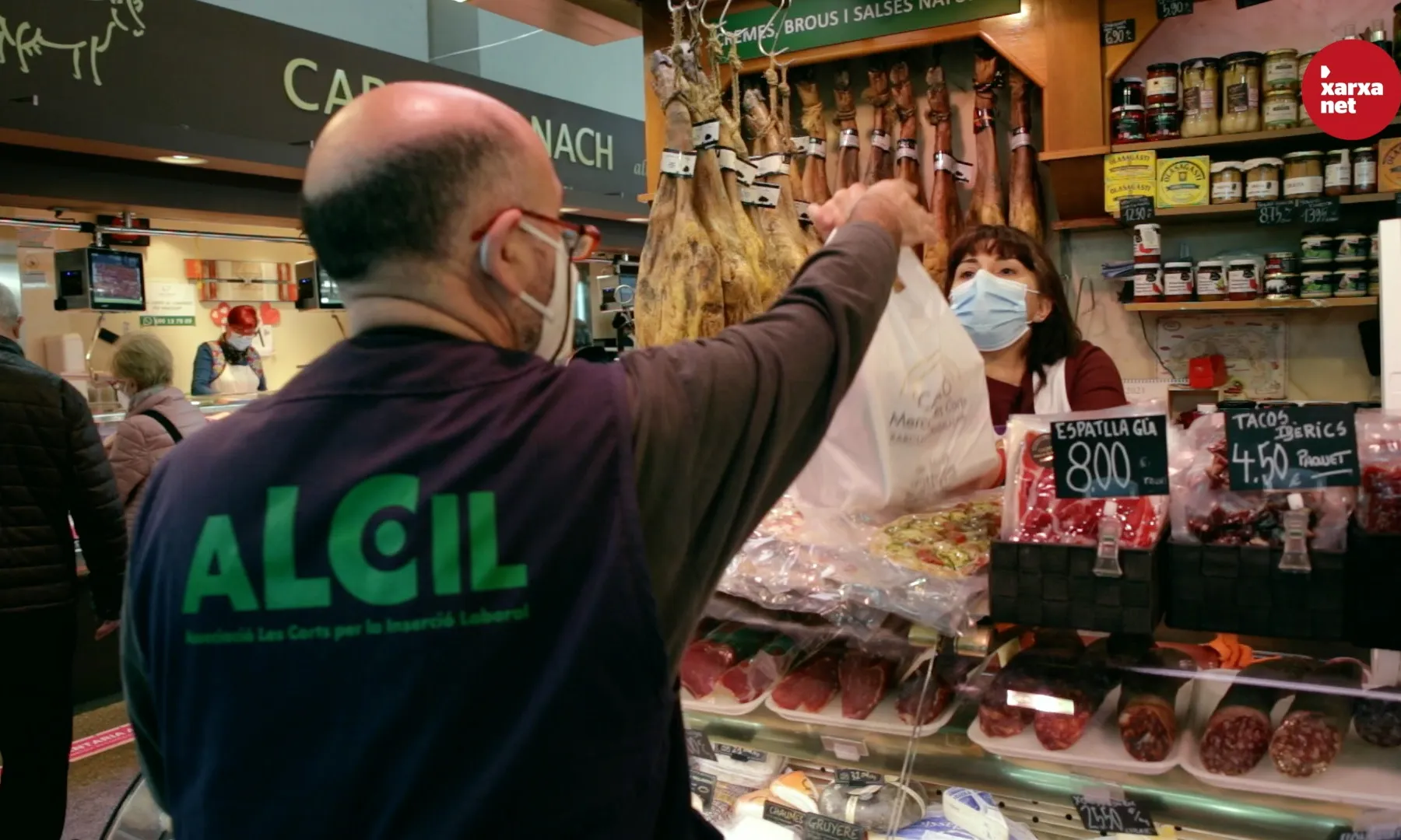Joan Manel Casado recull una de les comandes en una parada del Mercat de Les Corts